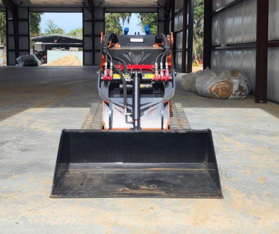 An image of one of the mini track loaders and it's bucket attachment.